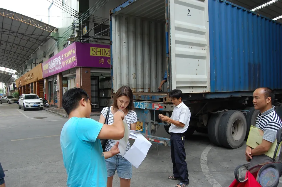 Reviewing shipment paperwork beside a container