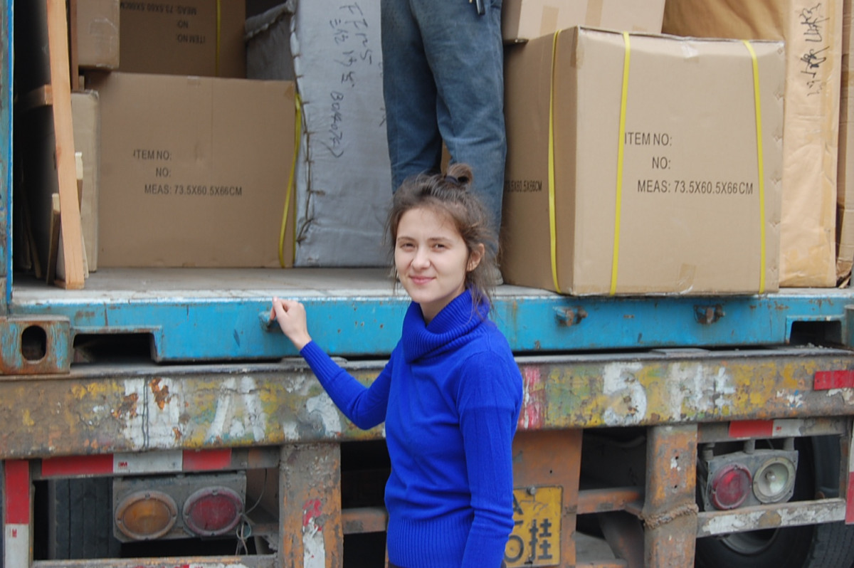 At the container loading area, with packed furniture behind